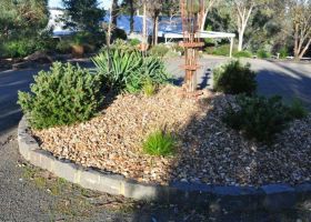 This circular garden bed adds character to the driveway.